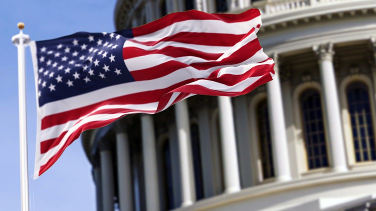 Die Flagge der Vereinigten Staaten von Amerika, die vor dem Kapitol gebäude verschwommen im Hintergrund - Stock-Fotografie