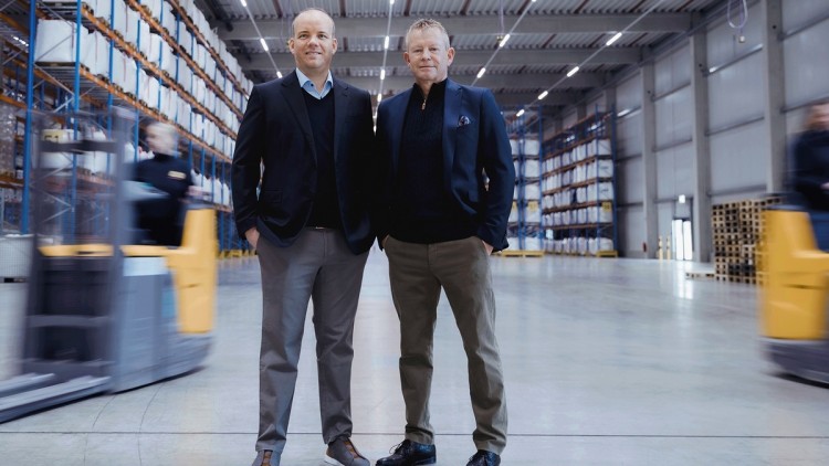 Jochen Geis (l.) und Hans-Wolfgang Geis stehen in einer Logistikhalle