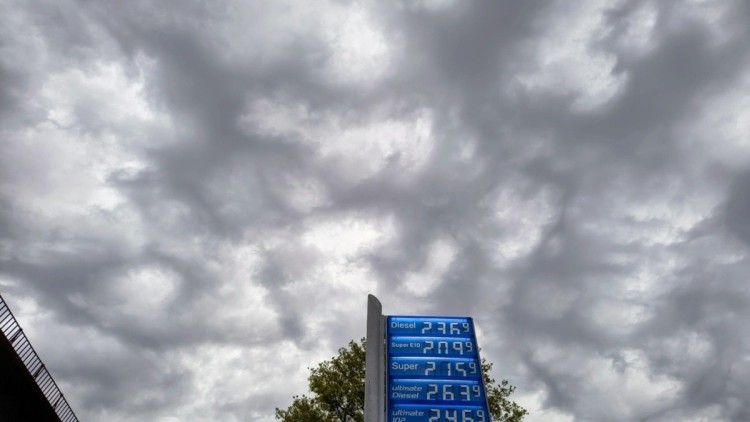 Hohe Kraftstoffpreise vor bewölktem, düsteren Himmel