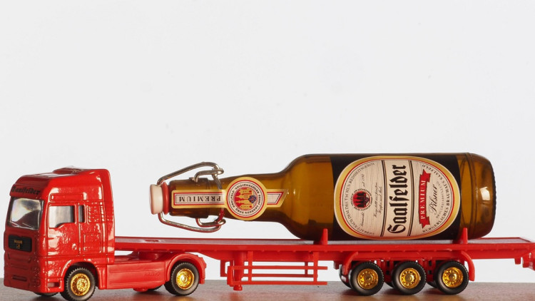 Eine Bierflasche liegt auf einem Anhänger eines Lkw