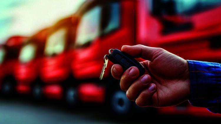 Hand hält Schlüssel vor Lkw