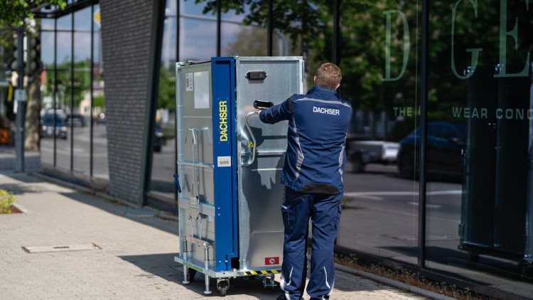 Mann schiebt Mehrwegsystem Dachser Retail Box über Bürgersteig