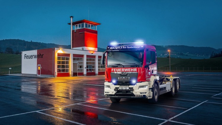 MAN-Feuerwehrfahrzeug vor dem Feuerwehrgebäude bei Nacht