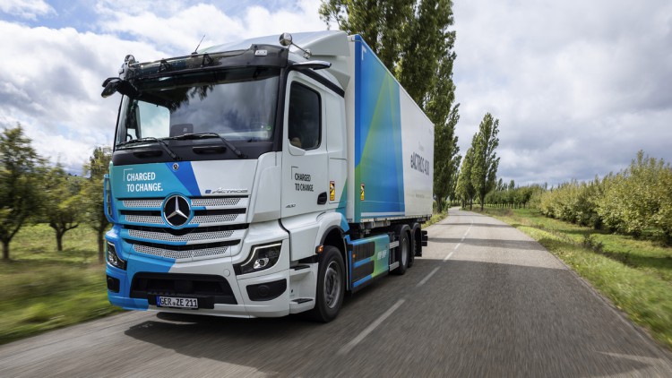 Ein Mercedes-Benz eActros 400 fährt als 6x2-Chassis mit Kofferaufbau durch die Landschaft
