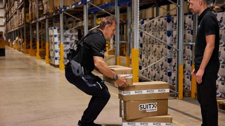 Ralf Moeller testet Exoskelett von SUITX by Ottobock im Lager bei Dachser