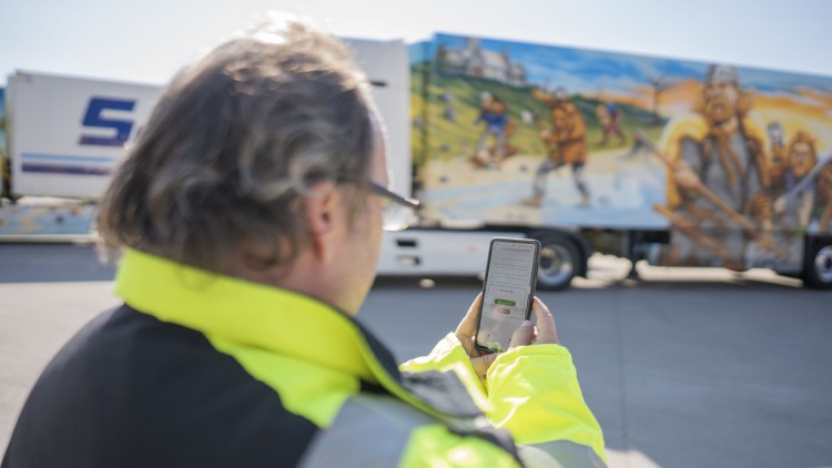 Lkw-Fahrer wickelt Begegnungsverkehr mit der Mansio-Software am Smartphone ab