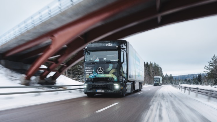 Die beiden seriennahen E-Lkw-Prototypen von Daimler Truck waren Anfang 2025 unter anderem unter winterlichen Härtebedingungen unterwegs. Im Bild die beiden E-Actros 600, wie sie in verschneiter Landschaft aber schneefreier Straße eine Brücke unterqueren. 