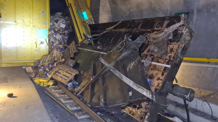 Ein schräg stehender entgleister Güterwagen steht vor einem gelben Spurwechseltor im Gotthard-Basistunnel.