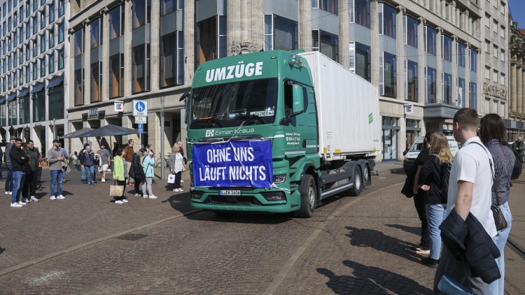Ein Umzugs-Lkw mit einem Banner „Ohne uns läuft nichts“ fährt im Rahmen einer Protestveranstaltung gegen die hohen Kraftstoffkosten am 17. April 2026 über den Leipziger Augustusplatz