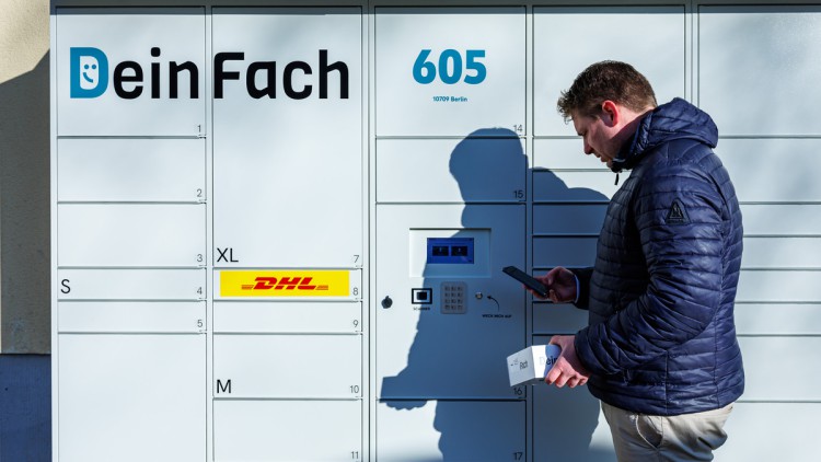 DeinFach-Geschäftsführer Lukas Beckedorff vor einem der weißen Paketautomaten der DHL-Tocher