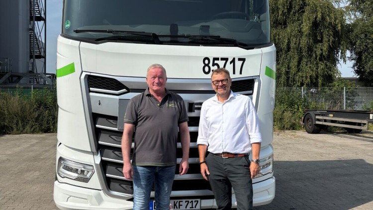 LIT-Vorstandsmitglied Ingo Schreiber (r.) und Michael Henschel, Geschäftsführer der Kombi Fracht GmbH, stehen vor einem neuen DAF-Lkw im Kombifracht-Design, der im Rahmen der Übernahme angeschafft wurde