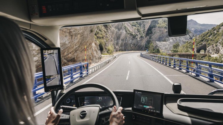 Person lenkt einen Volvo Truck über kurvenreiche Straße