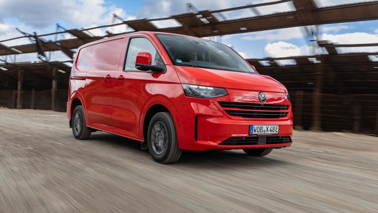 Fahraufnahme eines VW eTransporters von der rechten Fahrzeugseite. Der Kastenwagen ist in Rot lackiert 