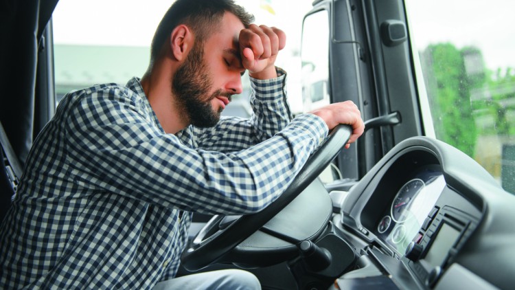 Mann erschöpft hinterm Lkw-Steuer