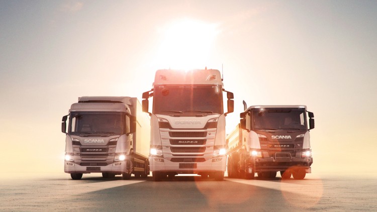 Drei Scania-Lkw im Sonnenuntergang