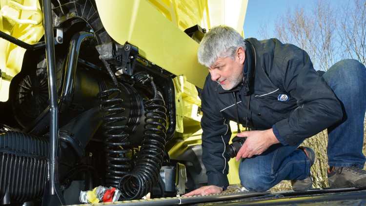 Ein Gutachter von TÜV SÜD sieht sich einen Schaden an einem Lkw an