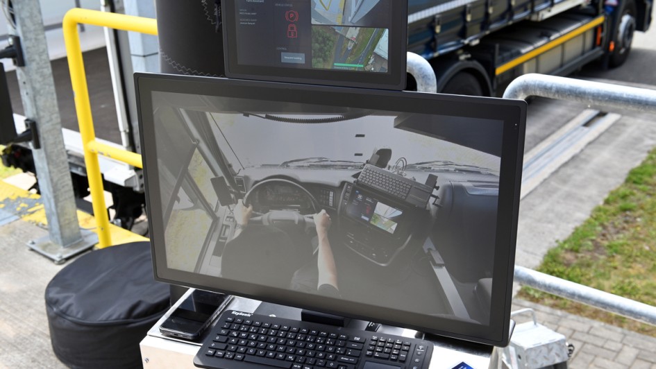 Auf einem Bildschirm ist das Bild von einer Person hinter dem Lenkrad eines Lkw zu sehen. Das Ganze ist Teil des Projekts "Smarter Lkw" von ZF 