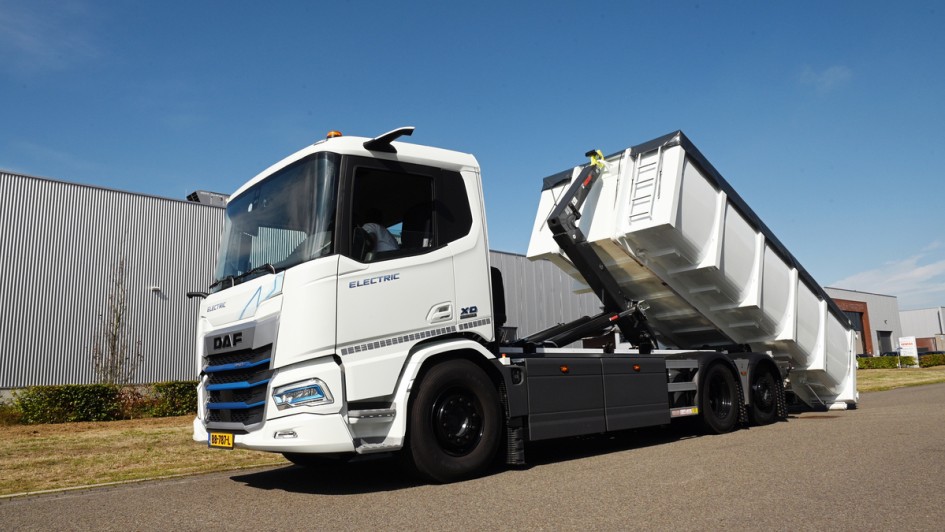 Ein in Weiß lackierter DAF XD Electric beim abrollen eines Abrollcontainers 