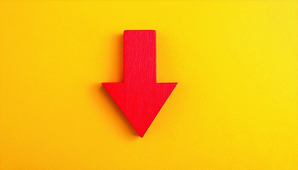 Roter Pfeil zeigt auf gelbem Hintergrund nach unten