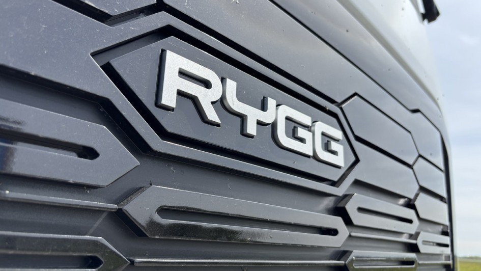 Nahaufnahme des Kühlergrills einer Sattelzugmaschine mit sichtbar angebrachtem Modellschriftzug „RYGG“.