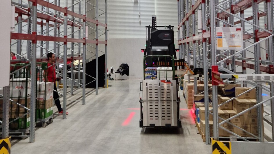 Automatisierter Hochhubwagen Linde RoCaP lagert in einem Regal Ware aus