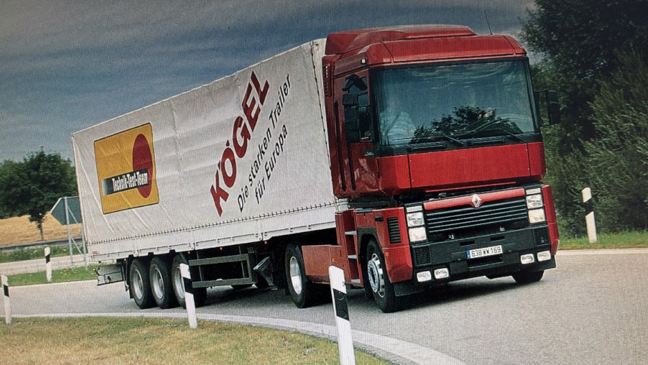 Ein roter Renault Magnum bei dynamischer Kurvenfahrt. Die zweiachsige Sattelzugmaschine zieht einen Gardinen-Trailer