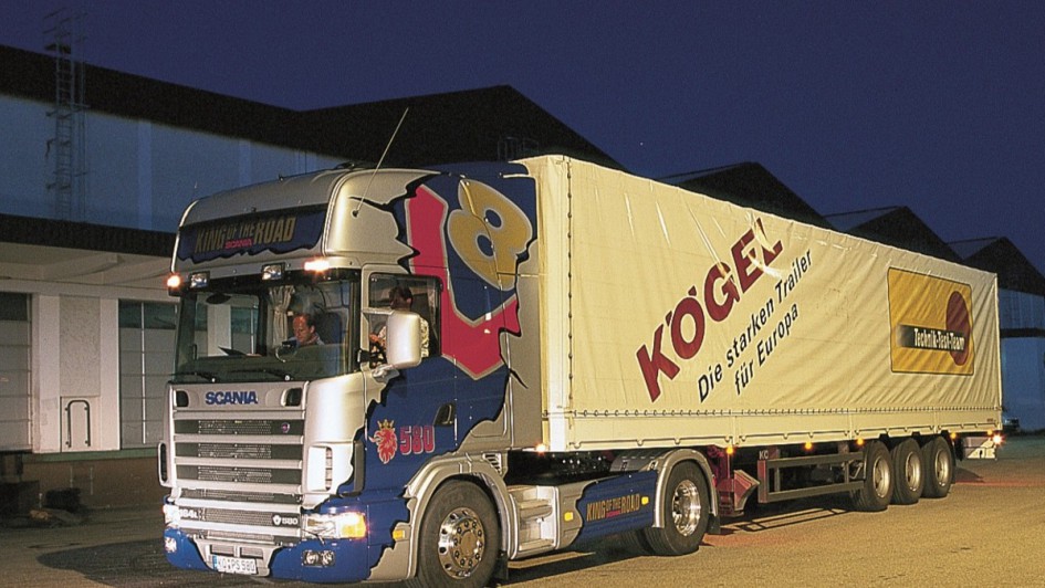 Ein Scania R 580 in bunter Lackierung wartet in abendlicher Stimmung auf seine Abfahrt