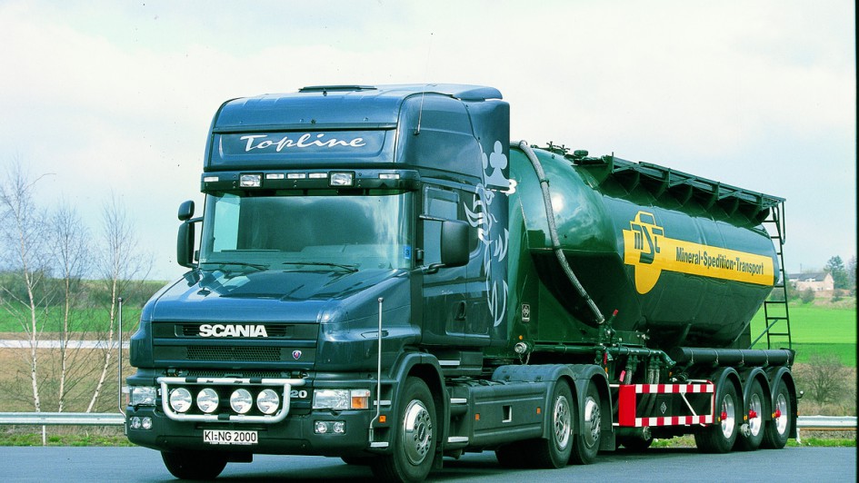 Ein schwarz lackierter Scania-Hauber mit drei Achsen steht mit einem aufgesattelten Silo-Trailer auf einem Parkplatz