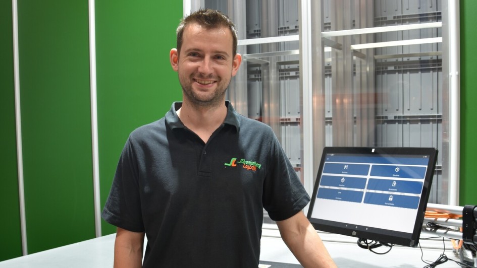 Sebastian Schenkelberg steht vor einem der Arbeitsplätze seiner Autostore-Anlage