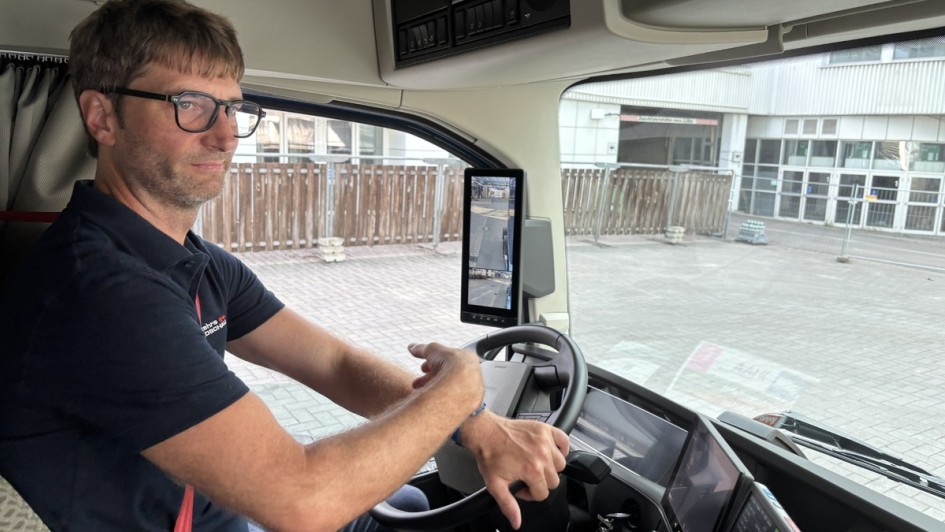 Blick auf den Fahrerplatz des Volvo FH Wasserstoffverbrenner. Zu sehen ist ein Fahrer auf dem Fahrersitz der das Lenkrad nach rechts dreht