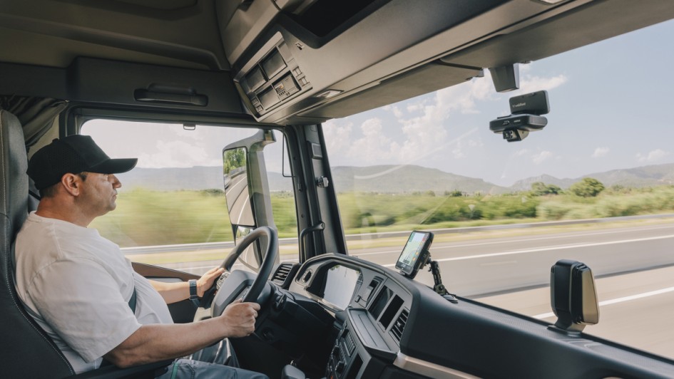 Lkw-Fahrer in einem Lkw mit Dashcam an der Windschutzscheibe