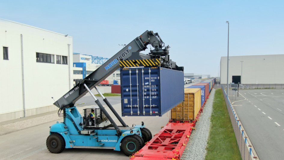 Reach Stacker hebt Container von Bahn